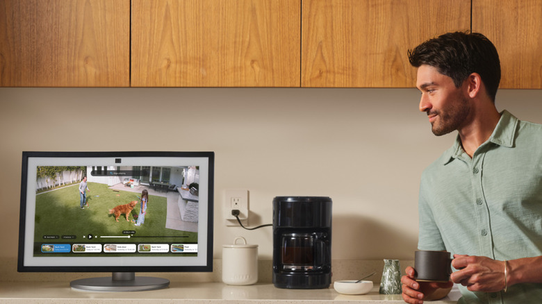 Человек пьет кофе и смотрит прямую трансляцию с камеры на устройстве Echo.