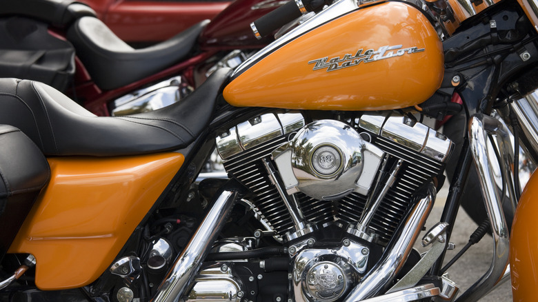 Горчично-желтый Harley-Davidson Road King с характерным двигателем Twin Cam 88 припаркован в помещении.