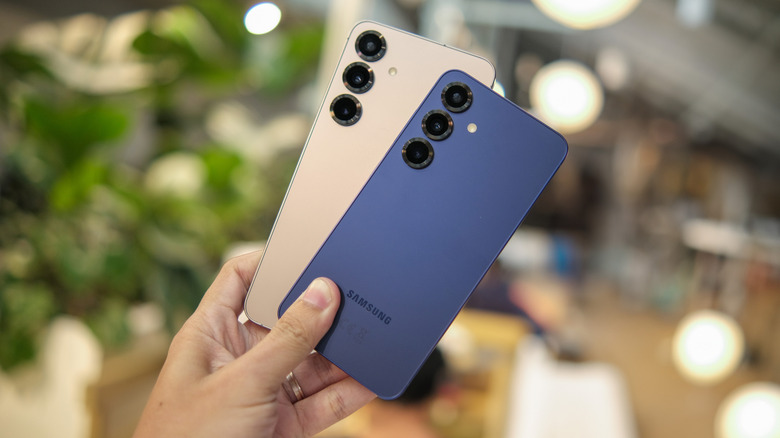 Человек держит два смартфона Samsung Galaxy