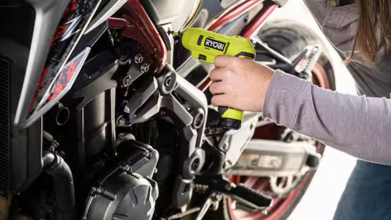 Отвертка Ryobi используется на мотоцикле