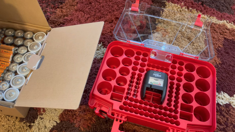 Battery Buddy с коробкой разных батареек рядом.