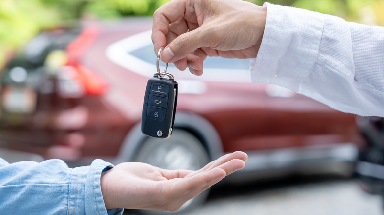 Человек передает ключи от автомобиля другому.