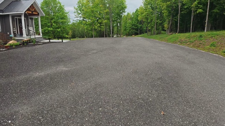 Подъездная дорога из переработанного асфальта перед домом.