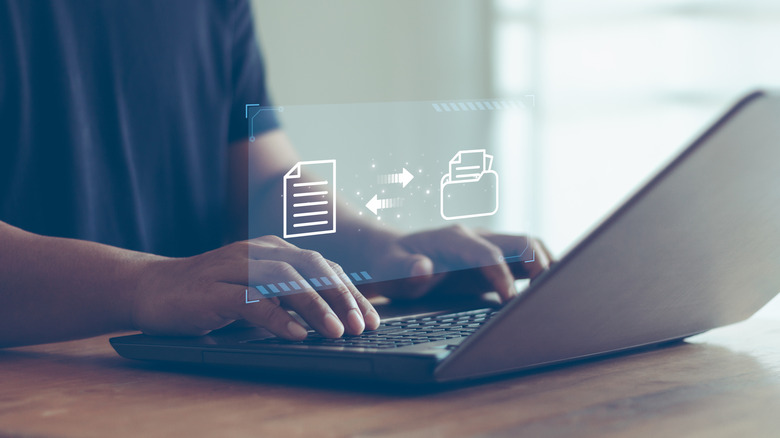 Человек печатает на ноутбуке, поверх которого наложено изображение передачи файлов.