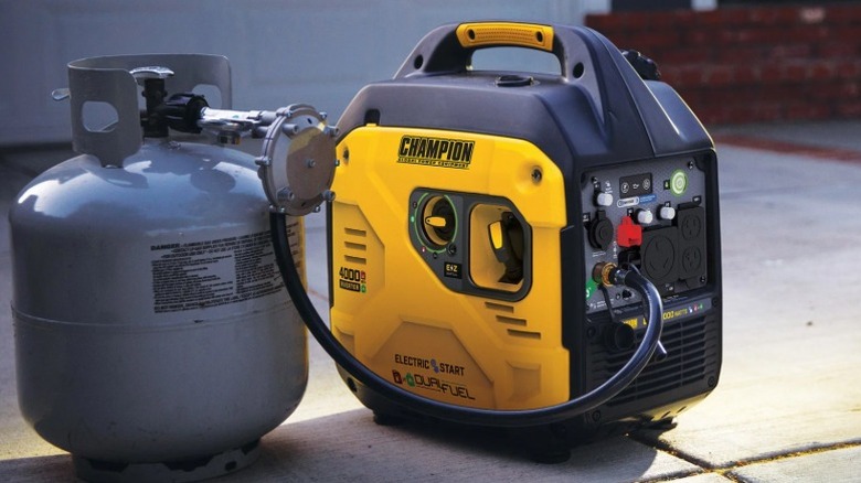 Двухтопливный инверторный генератор Champion на земле рядом с канистрой с бензином