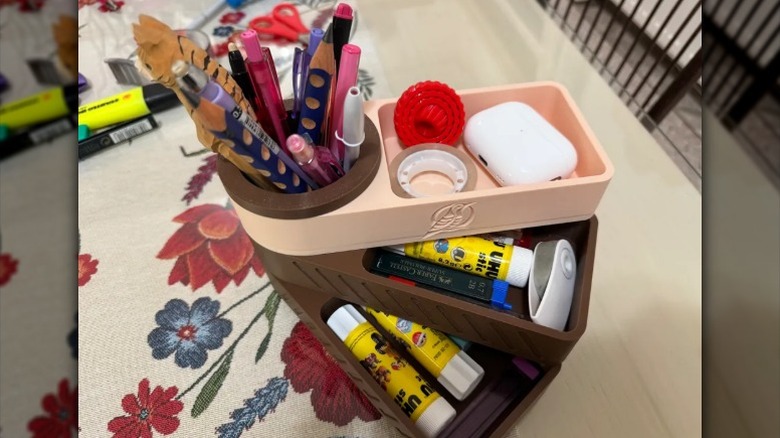 Настольный органайзер с вращающимися ящиками, полный вещей.