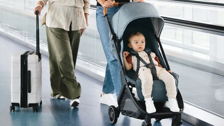 Женщина везет ребенка по аэропорту в легкой коляске Uppababy Minu V3