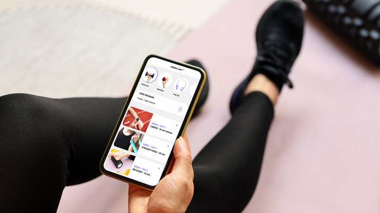 Человек, отслеживающий свои тренировки на телефоне