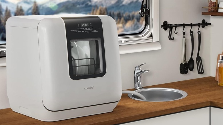 Посудомоечная машина Comfee стоит на стойке в фургоне.
