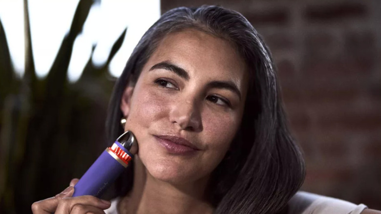 Устройство Therabody TheraFace используется на лице женщины