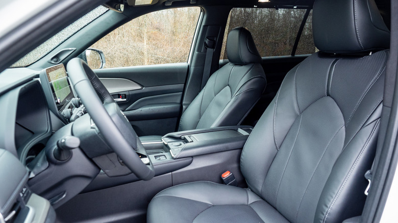 Toyota Grand Highlander Hybrid Nightshade 2026 года, вид со стороны водителя на сиденья переднего пассажира, приборную панель и рулевое колесо