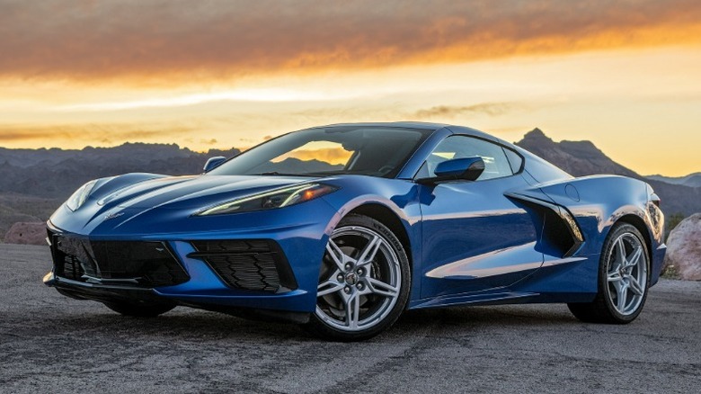 Синий Chevrolet Corvette Stingray 2020 года припаркован на пустынной дороге на закате