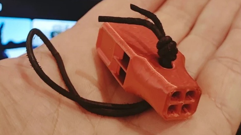 Туристический свисток в руке