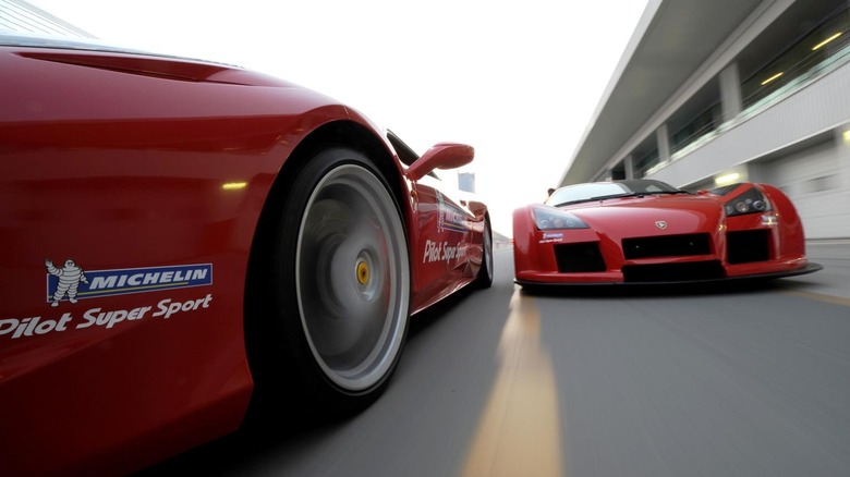 Два красных гиперкара на трассе с наклейками на шинах Michelin на обеих машинах
