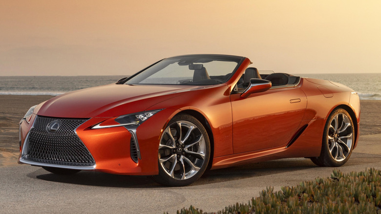 Вид спереди на 3/4 кабриолета Lexus LC 500 на пляже у моря