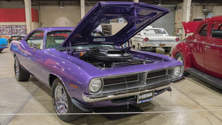 Plymouth Hemi 'Cuda 1970 года с открытым капотом, припаркованный в помещении на автосалоне, вид спереди справа