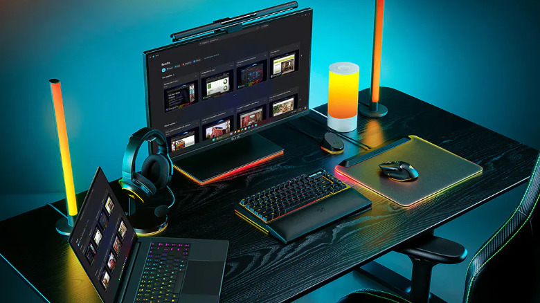 Razer Blade 16 на столе, подключенный к монитору, клавиатуре и компьютеру.