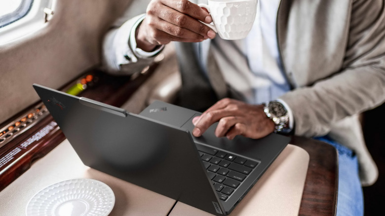 Человек, использующий Lenovo Thinkpad X1 Carbon Gen 12 в поезде.