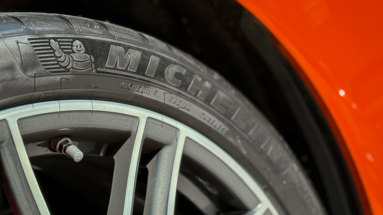 Крупный план логотипа Michelin на шине красного автомобиля