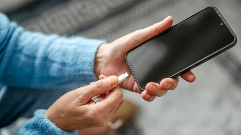 Человек подключает зарядное устройство Type-C к своему телефону