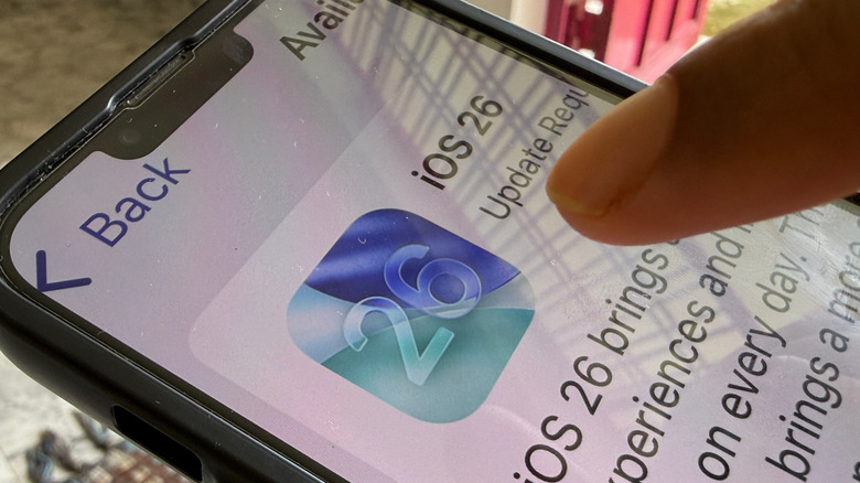 Человек обновляет свой iPhone до iOS 26