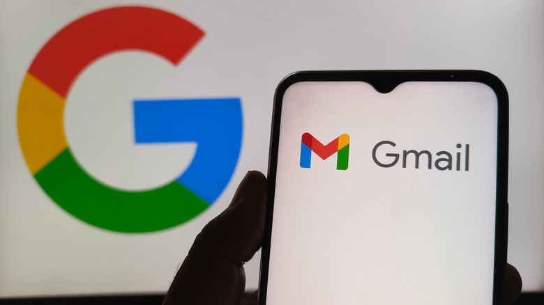 Логотип Gmail на телефоне на фоне логотипа Google