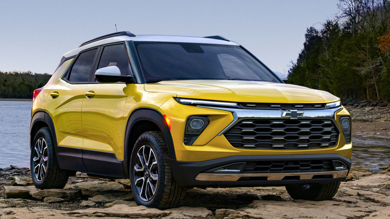 Вид спереди на 3/4 Chevrolet Trailblazer на скалистом берегу у озера