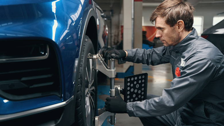 Мужчина делает выравнивание колес в магазине