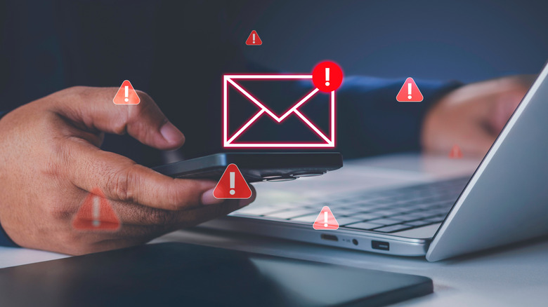 Человек нажимает на электронное письмо с красными значками предупреждения