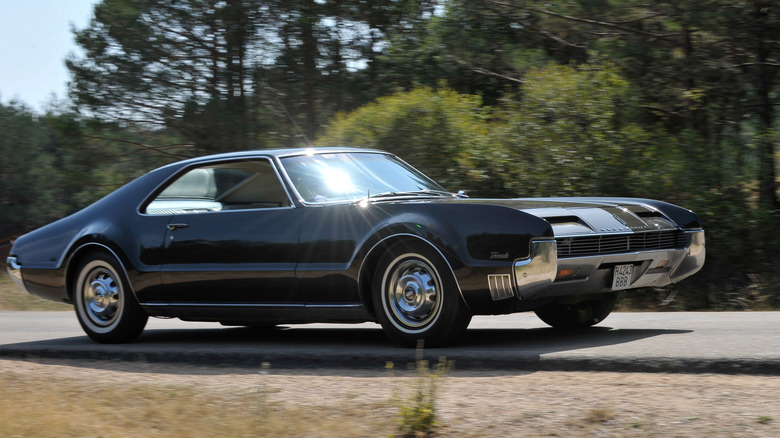 Oldsmobile Toronado 1966 года едет по дороге, вид спереди справа в 3/4