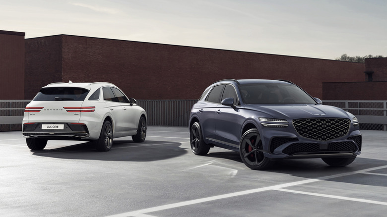 Два внедорожника Genesis GV70 припаркованы рядом друг с другом в городской черте.