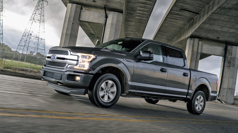 Ford F-150 2018 серого цвета проезжает мимо подземного перехода, вид спереди в 3/4