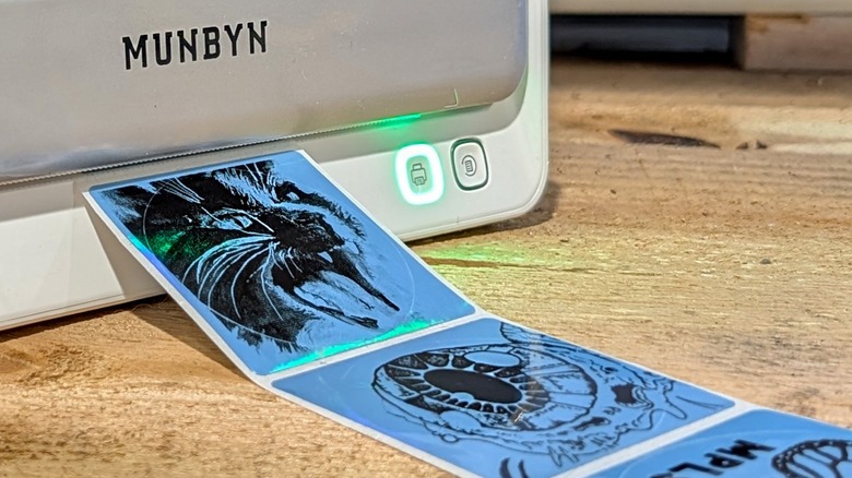 Принтер Munbyn с несколькими наклейками на деревянной поверхности.