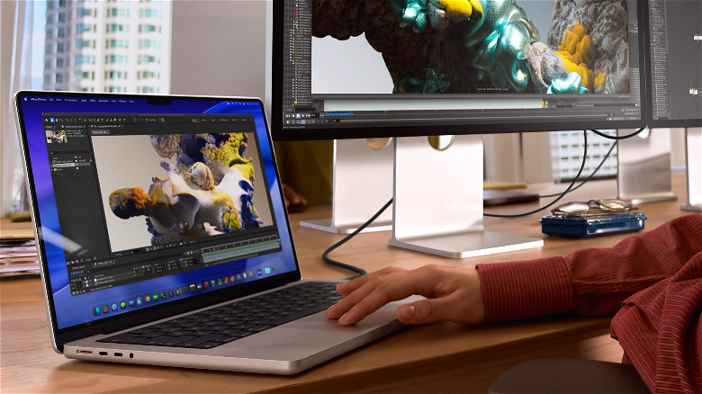 MacBook Pro M5 на столе рядом с настольным ПК.