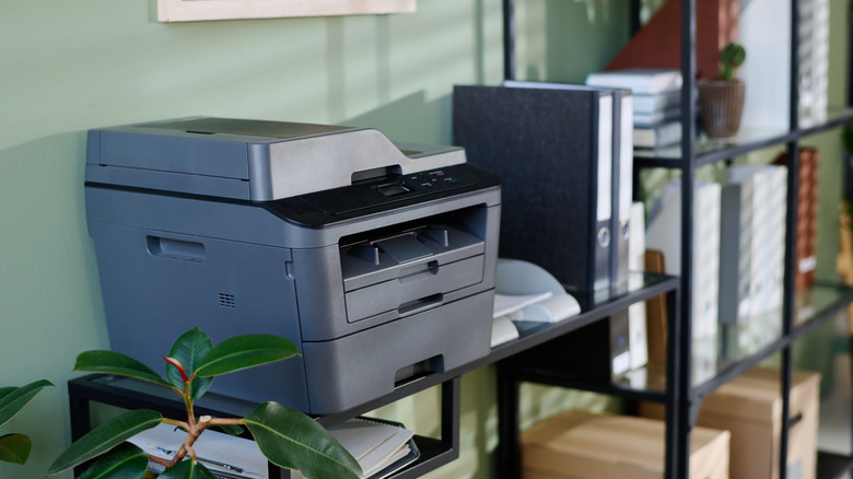 Принтер на столе спиной к стене.