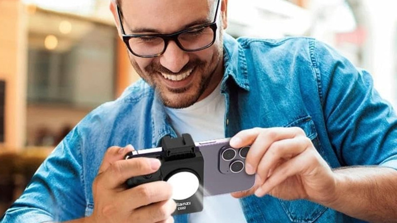 Мужчина использует на своем iPhone Bluetooth-смартфон Ulanzi Cap Grip, чтобы фотографировать.