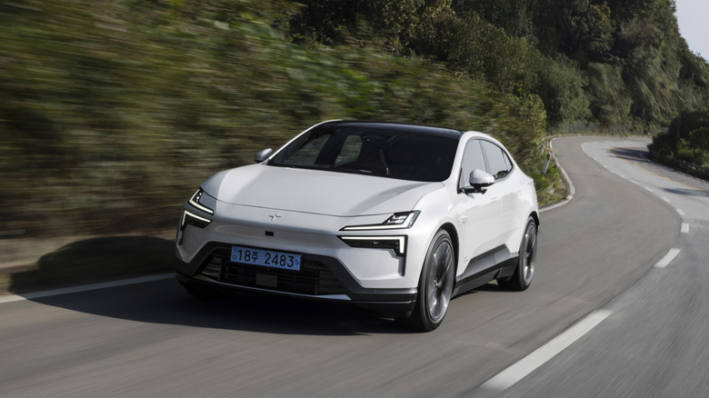 Белый Polestar 4 на дороге, вид спереди на 3/4, корейские номера.