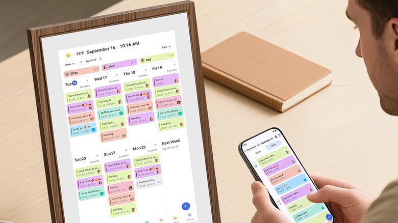 Мужчина пользуется цифровым календарем на столе