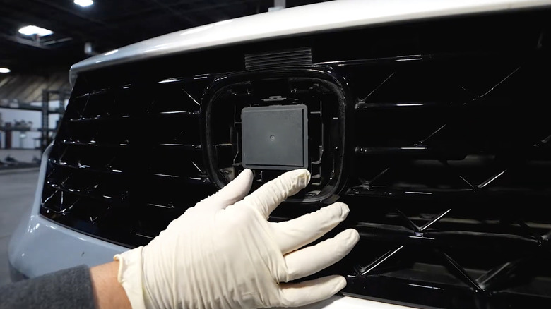 Радарный датчик Honda, установленный в пустой кожух на решетке автомобиля.