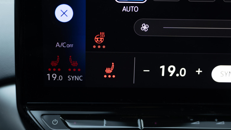 На экране информационно-развлекательной системы автомобиля показано, что сиденья нагреваются.