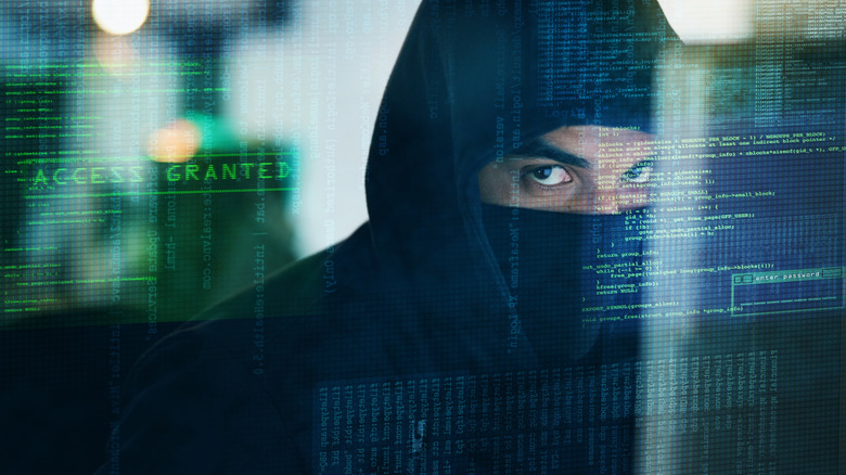 Подозрительный мужчина в балаклаве с наложением компьютерного кода