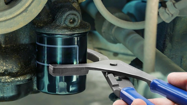 человек, использующий ключ для масляного фильтра