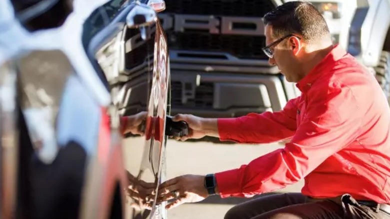 Человек, осматривающий шину