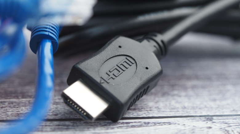 Различные кабели и разъемы HDMI расположены на деревянном столе.