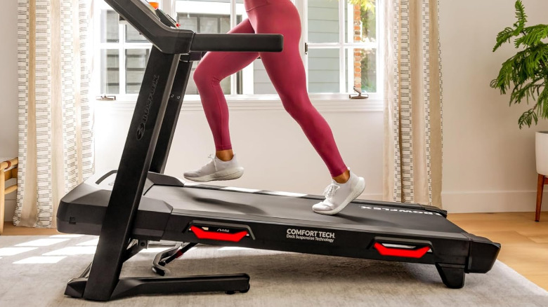 Bowflex BXT8J в гостиной, по нему бегает человек.