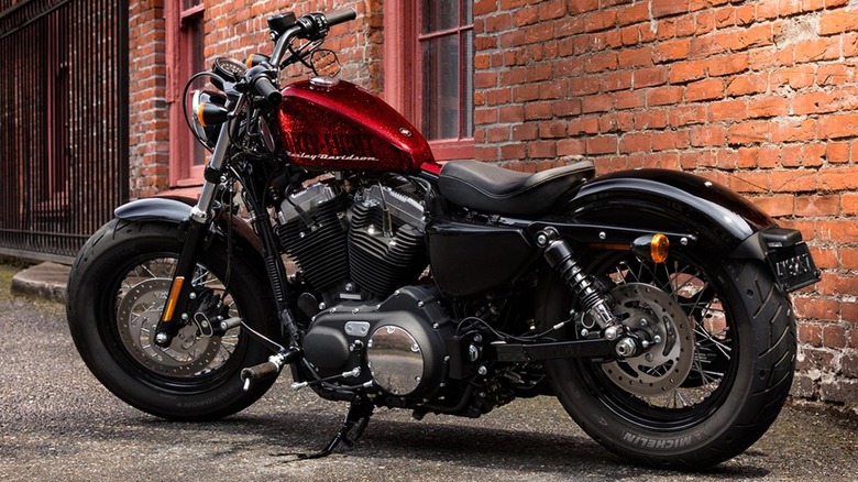 Красный Harley-Davidson с шинами Michelin перед зданием из красного кирпича.