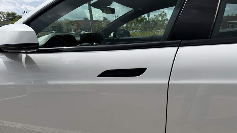 Tesla Model Y, белый со скрытыми черными дверными ручками, дверь водителя крупным планом
