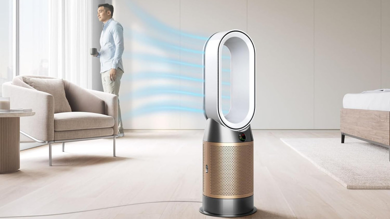 Человек в гостиной наслаждается воздухом, нагнетаемым очистителем Dyson Hot+Cool HP2 De-Nox.