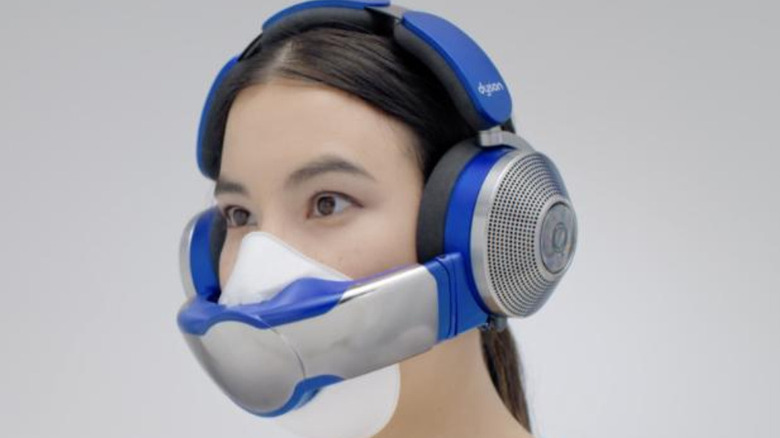 Человек в наушниках Dyson Zone с козырьком для лица