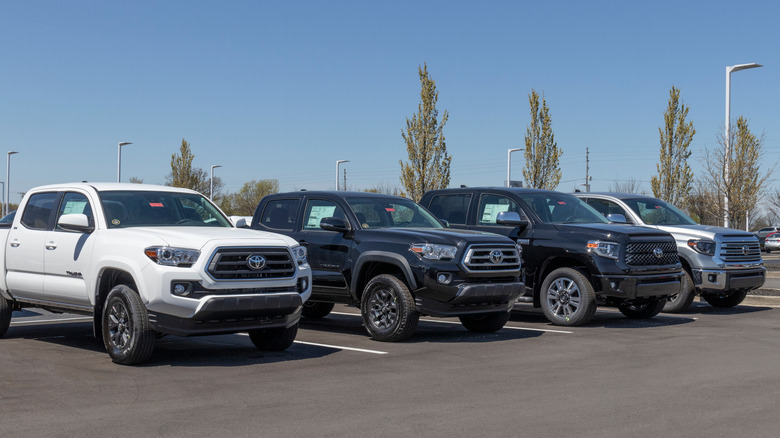 Вид спереди на пикапы Toyota Tacoma и Tundra, припаркованные на автосалоне.